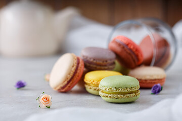 Colorful macarons on white table and wooden background