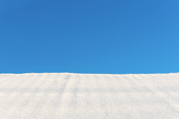 White snow and blue sky as winter background, copy space available