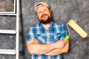 Joyful bearded foreman in green pants with working tools