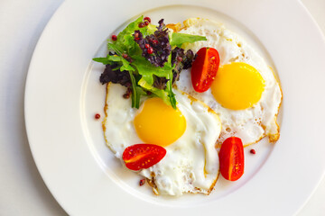 Tasty breakfast with scrambled eggs and tomatoes in restaurant