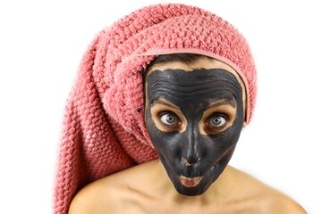 girl with a clay cosmetic mask on her face makes faces. Spa procedures. Isolated on white background