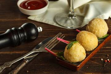 Arancini on a rectangular plate, vintage Cutlery and pepper mill. Close-up, Italian cuisine