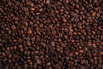 Scattered piles of roasted arabica coffee beans top view in daylight