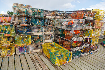 Colorful fishing crates filled with ropes, and bouys on a dock ready to be loaded,  for Lobster...