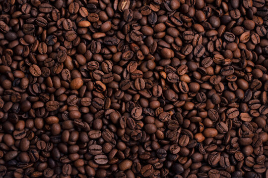 Scattered piles of roasted arabica coffee beans top view in daylight © Aleksandr Stupnikov