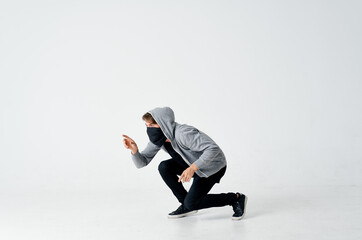 thief male hacker in a black mask and in a hood on a light background theft