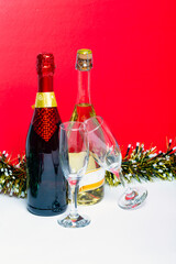 Champagne bottles with two glasses and multi-colored tinsel. Celebration theme with champagne still life. Template for postcards for Christmas and New Year 2021. Studio shot, high quality photo