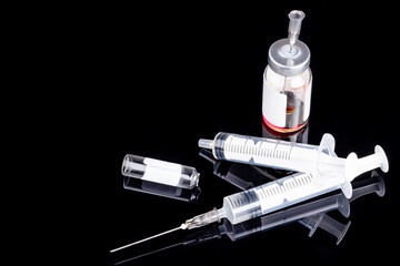 used syringes and ampoules isolated on a black background. copy space. medical injecting...