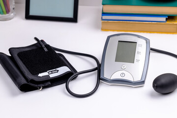 male person measuring blood pressure by using electronic medical monitor. employee overworked stress concept
