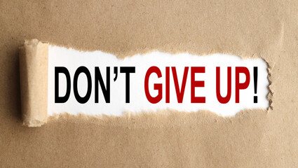 don't give up, text on white paper on craft envelope on wood background
