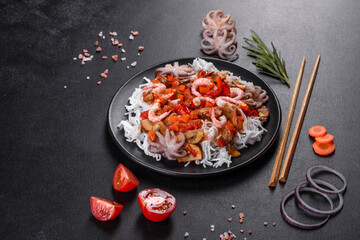 Tasty rice noodles with tomato, red pepper, mushrooms and seafood