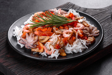 Tasty rice noodles with tomato, red pepper, mushrooms and seafood