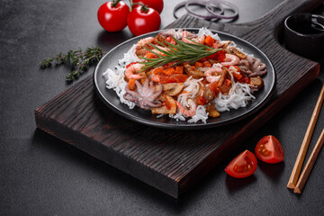 Tasty rice noodles with tomato, red pepper, mushrooms and seafood