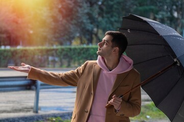 man with umbrella on the street checking if it rains