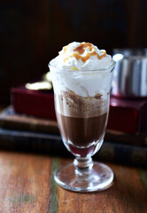 Coffee with whipped cream on dark wooden background. Close up.