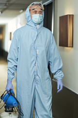 Obraz na płótnie Canvas Man in special protective clothing going to disinfect hotel rooms