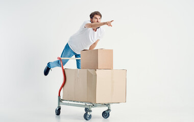 energetic courier with cardboard boxes transporting heavy cargo light background