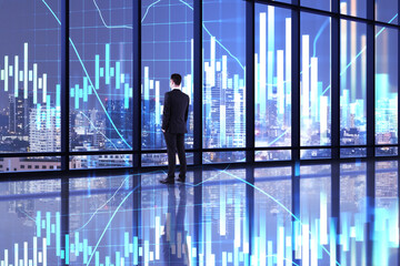 Fototapeta premium Thoughtful businessman standing in office room with glowing forex charts