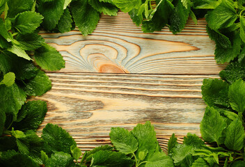 Wood background with fresh mint edging, suitable for tea drinks.Mint leaf frame.