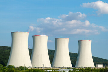 Nuclear power plant. Cooling towers on the background of blue sky and mountains