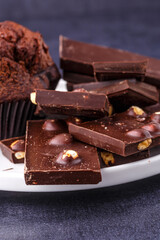 Chocolate cupcake with icing and chocolate bar in Dark lighting,Homemade delicious chocolate muffin on wooden background close-up