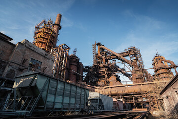 Blast furnace of metallurgical plant or chemical factory with industrial railroad and freight wagons. - obrazy, fototapety, plakaty