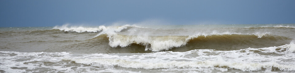 Foamy waves in the stormy Baltic sea in full sun, luminous glare.