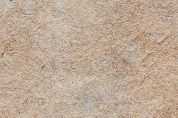 Natural vintage background of organic cardboard with various villi, fluff and other inclusions.