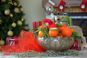 Christmas decoration and fruits on the table. Christmas background. Santa hat and fresh tangerines.
