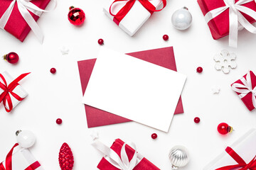 Christmas greeting card or invitation in frame made of gift boxes and holiday decorations on white background