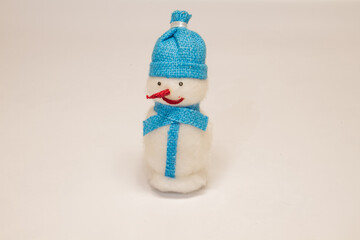 christmas toy snowman with red nose in blue hat with scarf isolated on white background