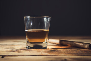 Whiskey and cigar on wooden background