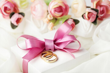 wedding rings and gift box and pink flowers. love symbol