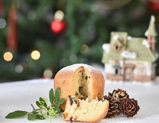Mini Panettone (Italian Christmas cake) with candied fruit with blurred Christmas lights flashing in the background. Vertical