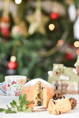 Mini Panettone (Italian Christmas cake) with candied fruit with blurred Christmas lights flashing in the background. Vertical