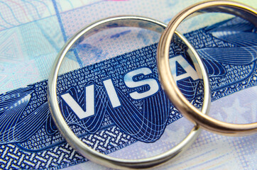Macro photo of US entry visa sticker in a passport and a couple of rings. Conceptual photo for immigration. Selective focus.