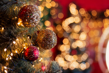 Obraz na płótnie Canvas beautiful colorful festive background. Red and gold balls close-up on Decorated Christmas tree branch. New year mood. Shine sequins glitter. Place for text banner. postcard screensaver traditional 