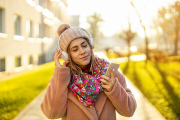 Happy young woman with headphones and cell phone
