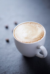 Cup of coffee on dark stone background. Close up. 