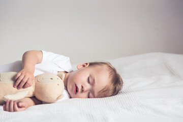 Baby sleeps with plush toy.