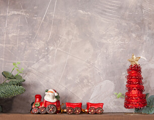 Red Christmas toy train with red Christmas tree and a gray copy space. Decorative concept of the Christmas holiday.