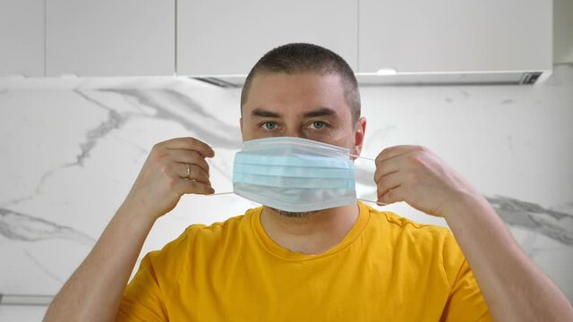 Man pu on medical mask stay at home. Covid-19 quarantine. Social distance concept
