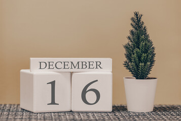 Desk calendar for use in different ideas. Winter month - December and the number on the cubes 16. Calendar of holidays on a beige solid background.