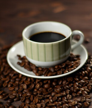 Cup of coffee and roasted coffee beans on a wooden table © Cupido