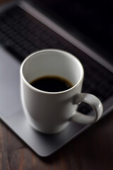Cup of coffee and notebook on a wooden office table
