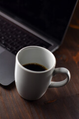 Cup of coffee and notebook on a wooden office table