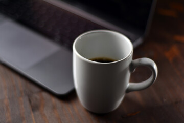 Cup of coffee and notebook on a wooden office table