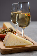 Glasses of dry fino sherry wine served with spanish tapas, manchego cheese, green olives, cheese crackers