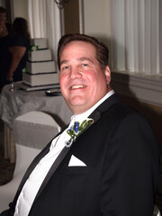 The happy groom poses for a portrait.