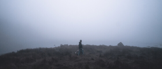 Woman standing on plains covered in thic fog